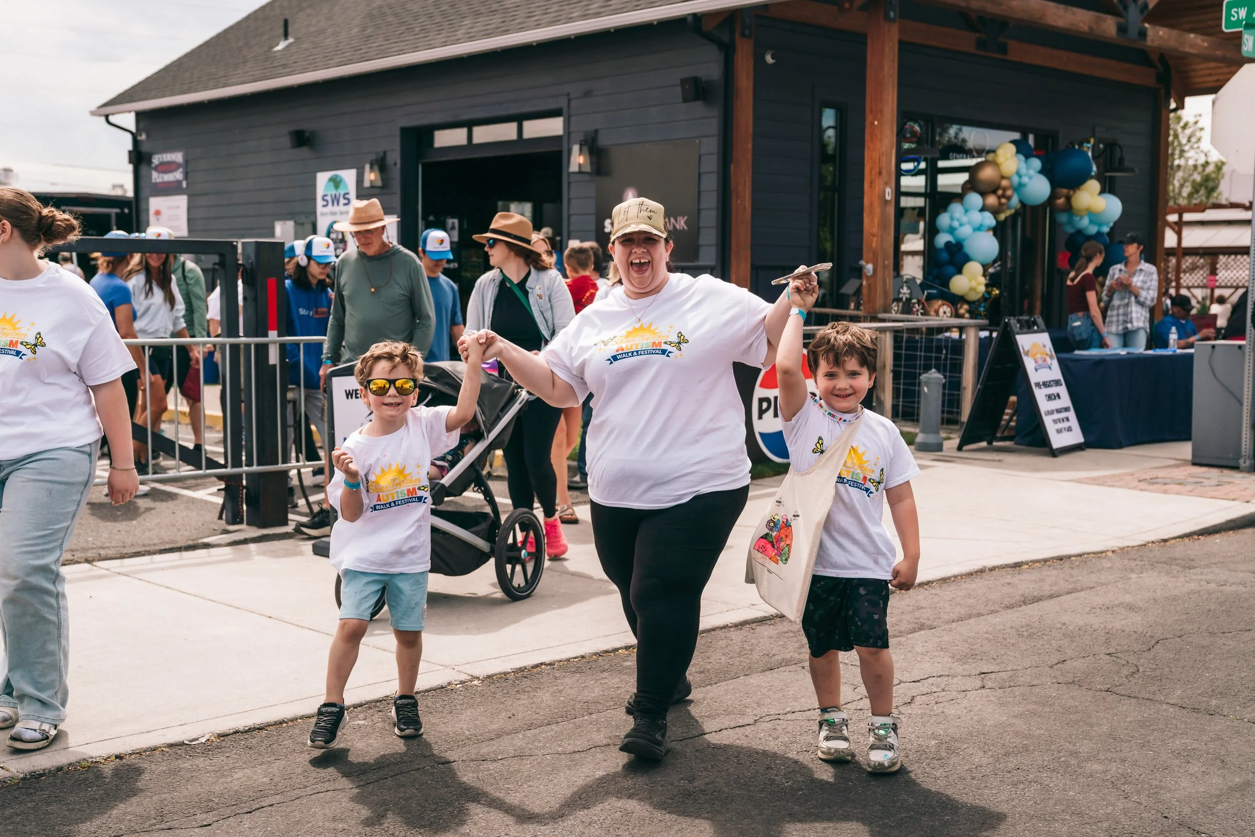 A family holding hands and celebrating at the Shine Together Autism Walk and Festival
