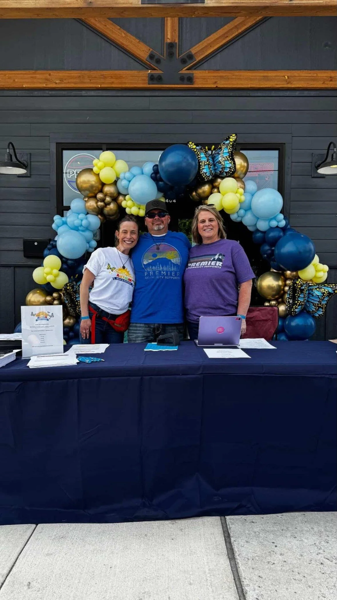 Community supporters at the Shine Together event welcome table and balloon arch