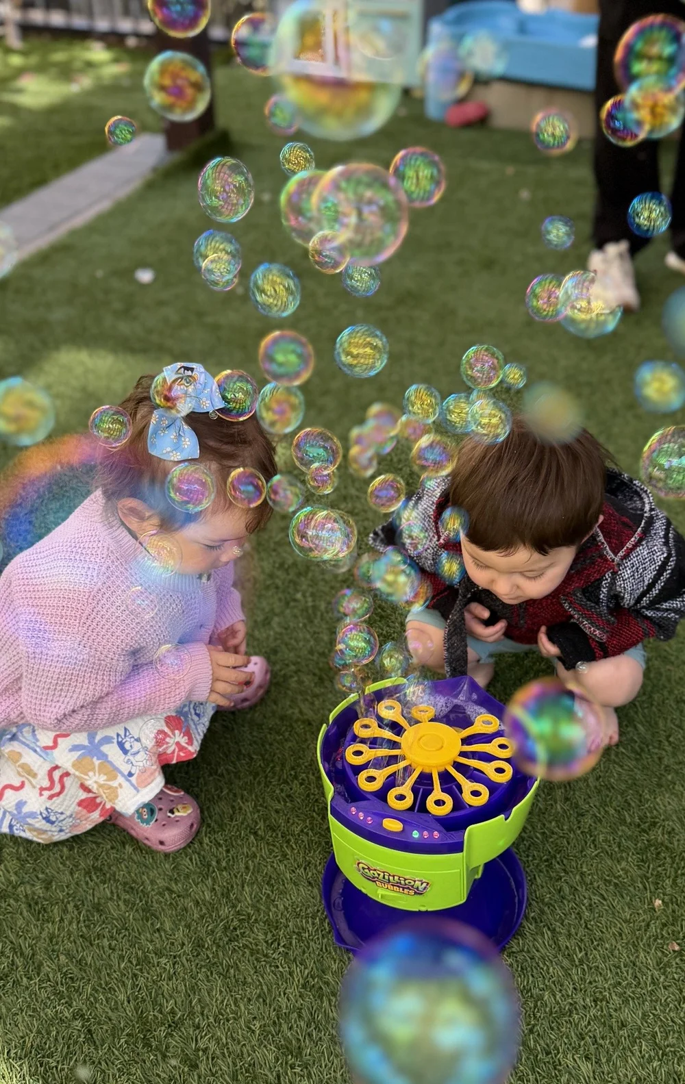 Children surrounded by bubbles during outdoor play