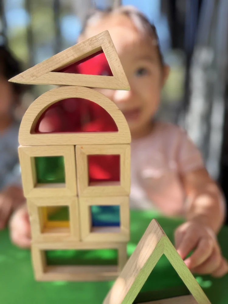 A child discovering shapes through colorful wooden building blocks