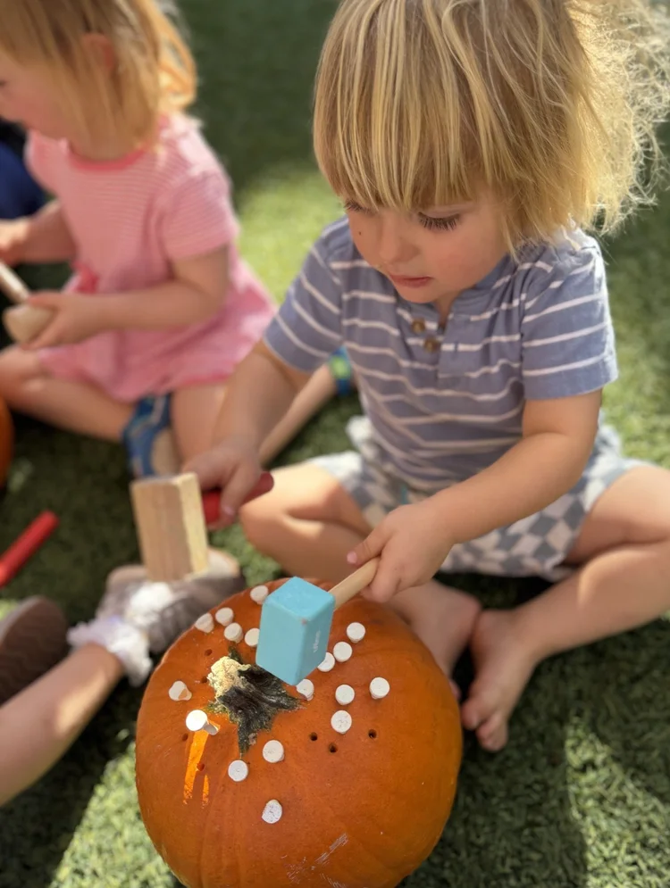 Children decorating a pumpkin together