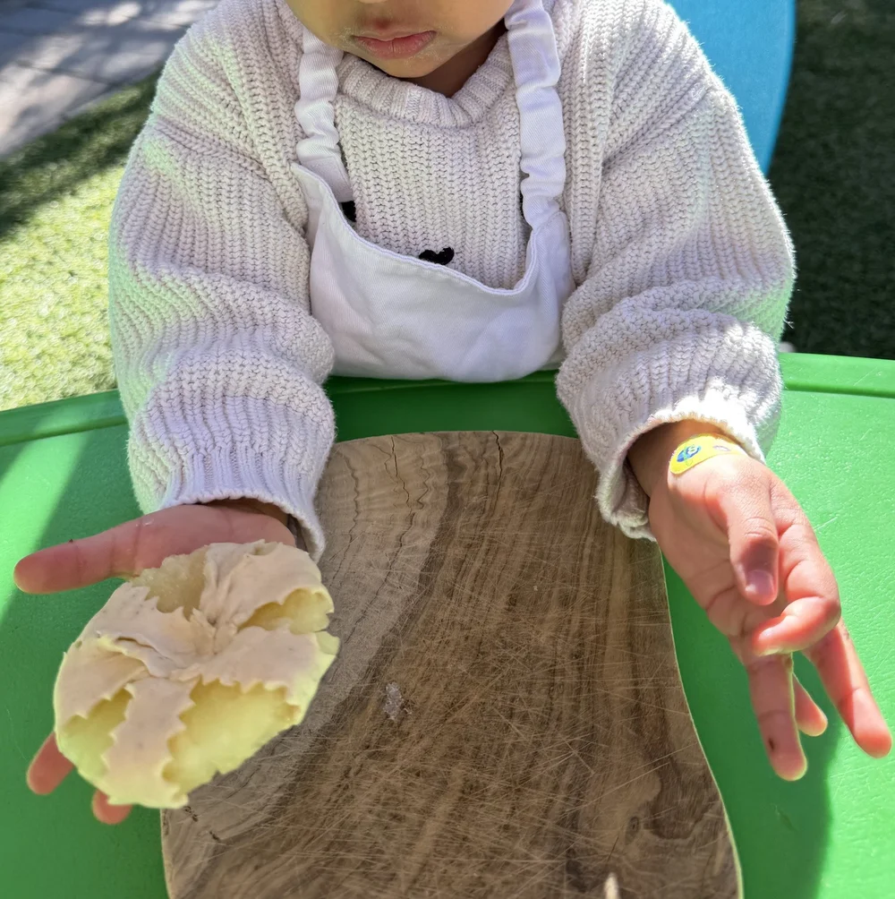 A child shaping soft dough with both hands