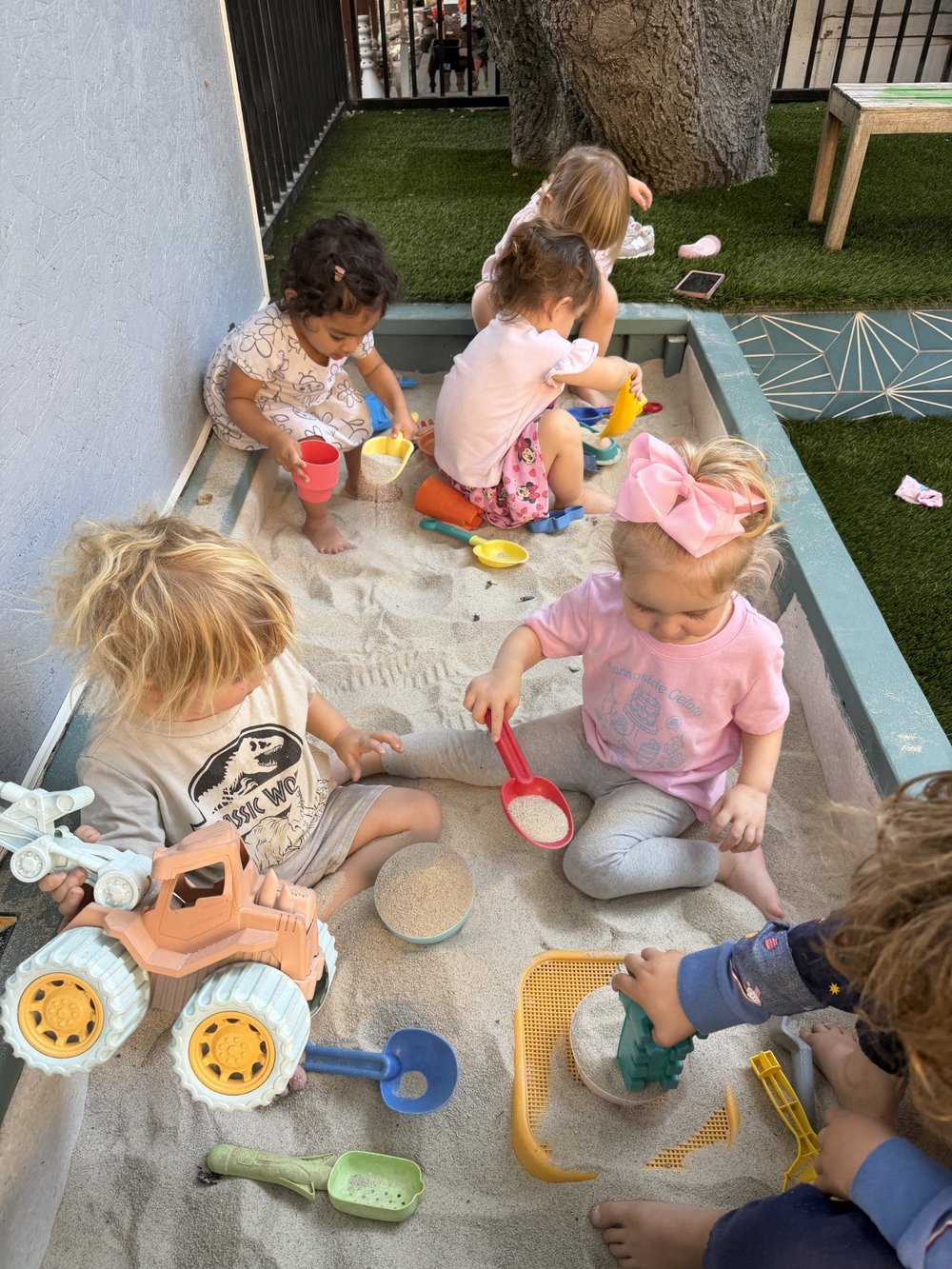 Children sharing pretend food and dishes around a table