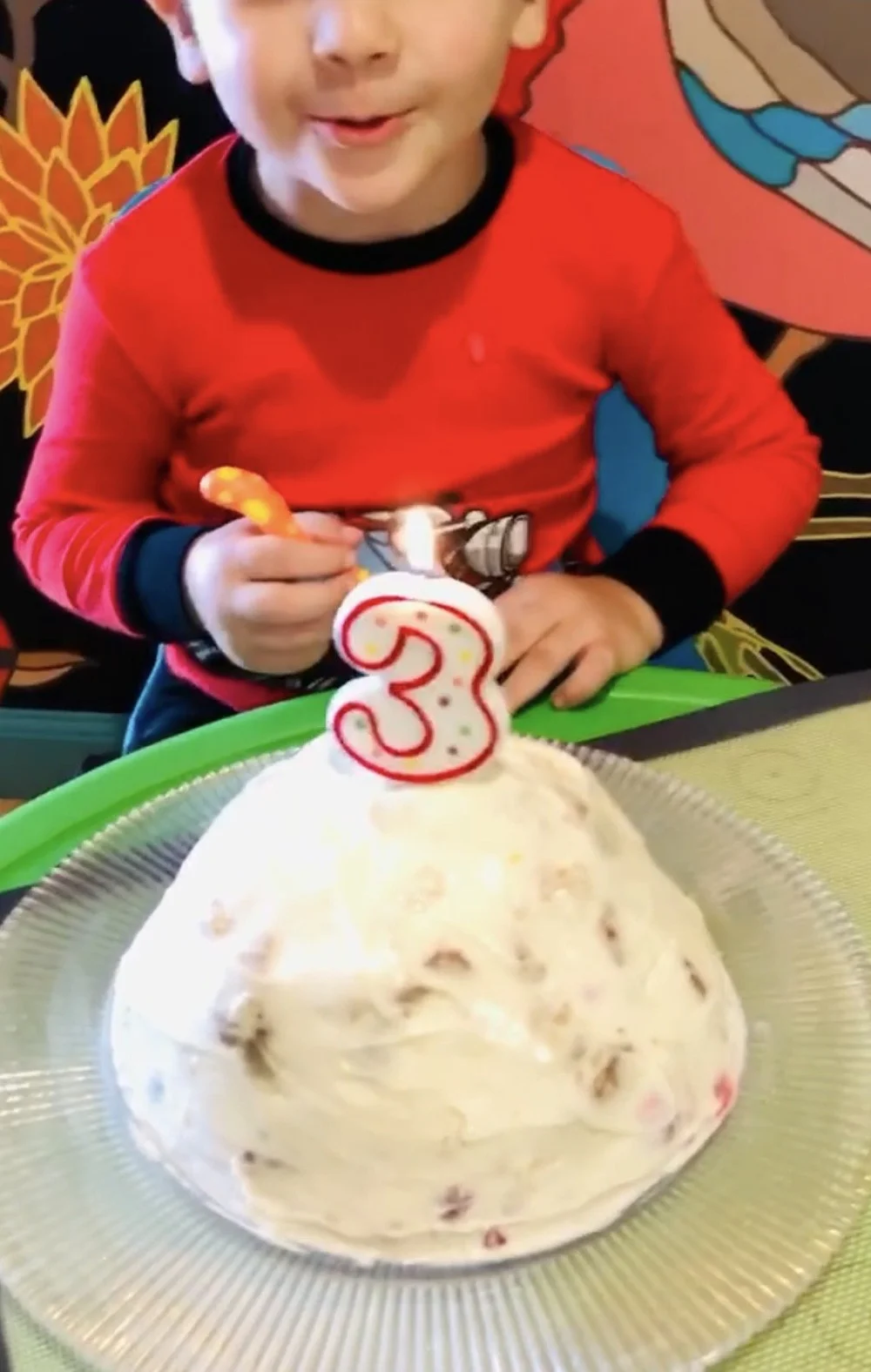 A child celebrating a third birthday with a homemade cake from Mila