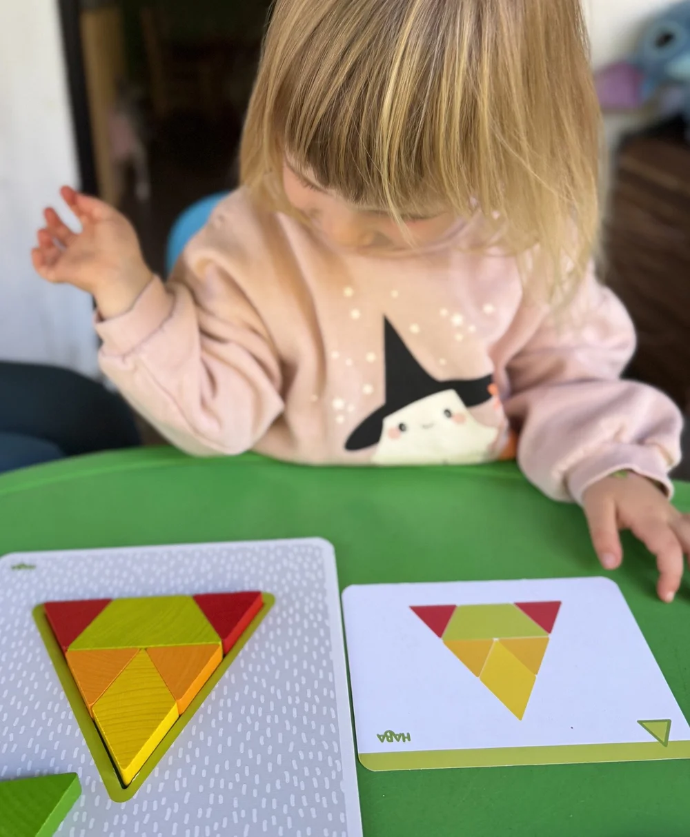 A child exploring a geometric wooden puzzle