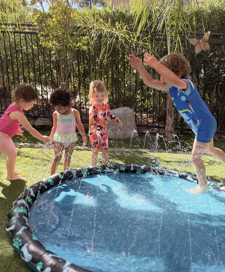 A group of children enjoying a circular outdoor splash pad