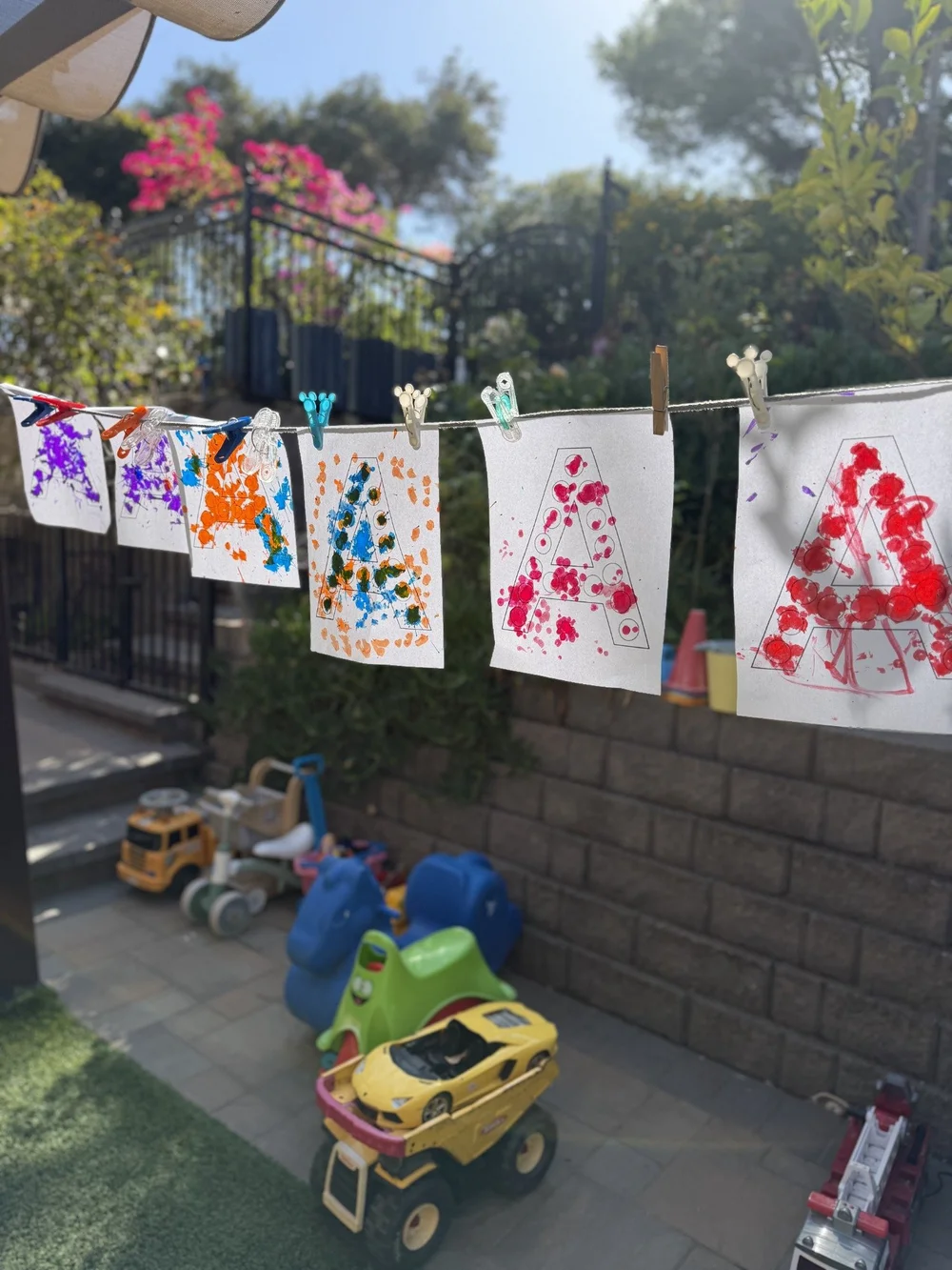 Children’s colorful artwork hanging on an outdoor clothesline