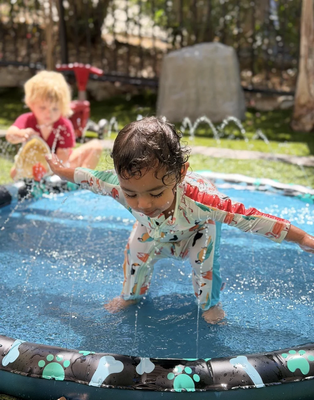 A young child smiling during water play