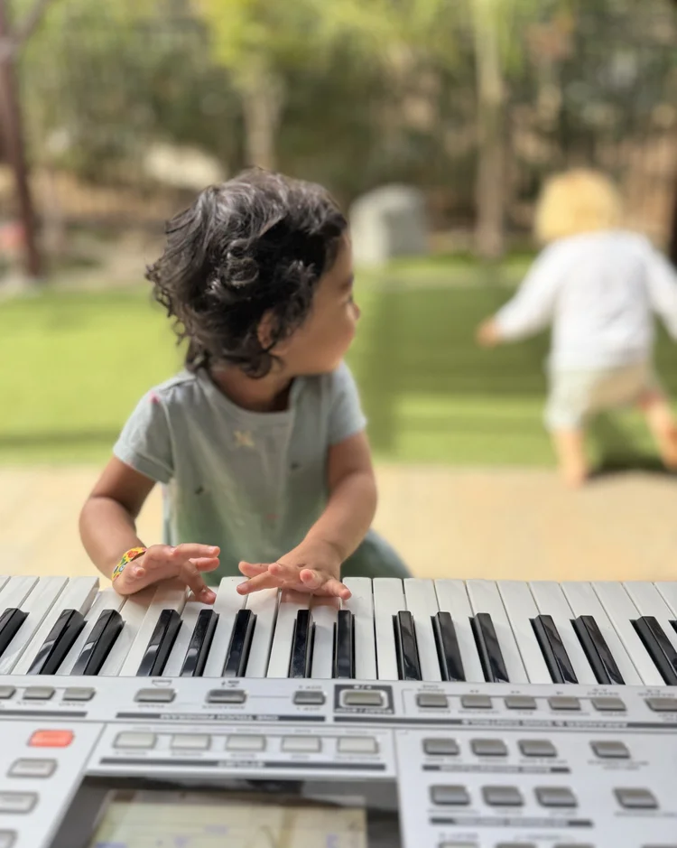 A child playing an electronic keyboard outdoors