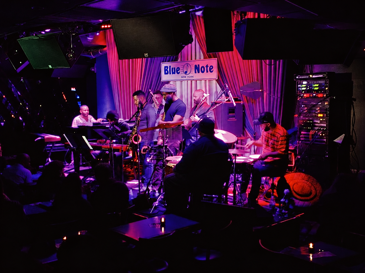 Ensemble performing on a purple-lit Blue Note stage