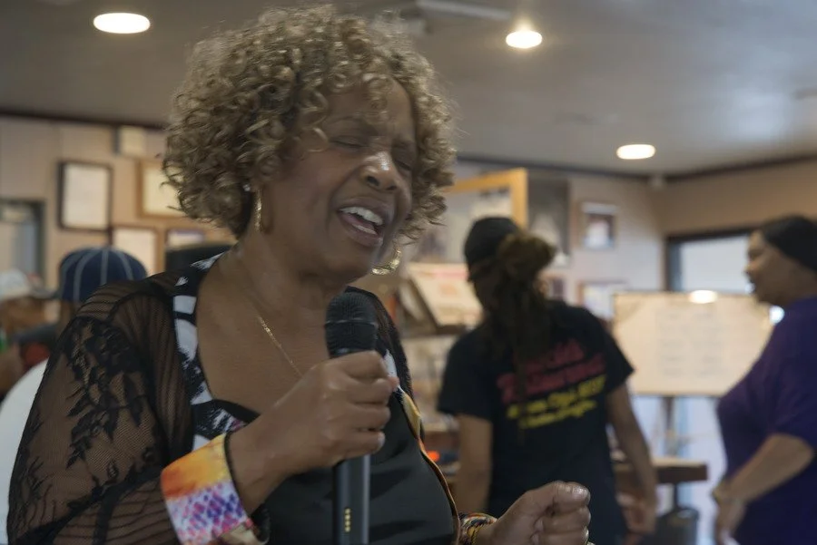 Niecie smiles while holding the microphone during Dinner and a Show in her restaurant