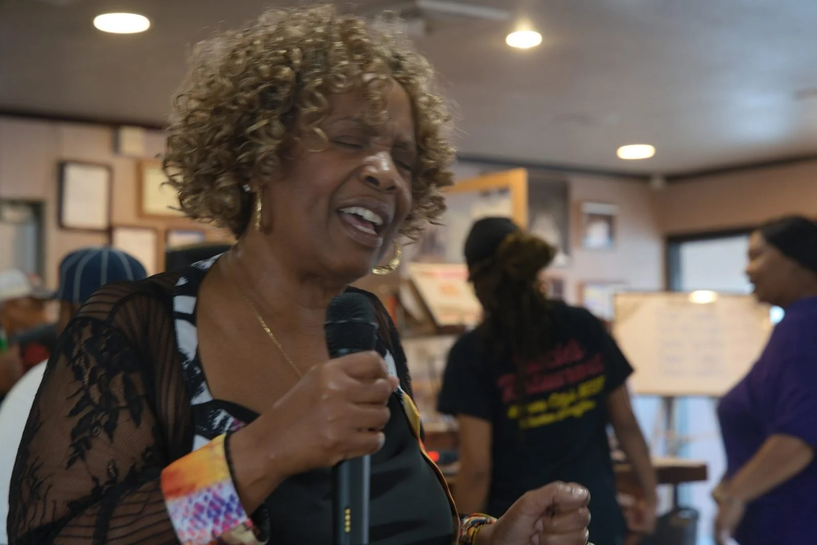 Niecie smiles while holding a microphone during Dinner & a Show.