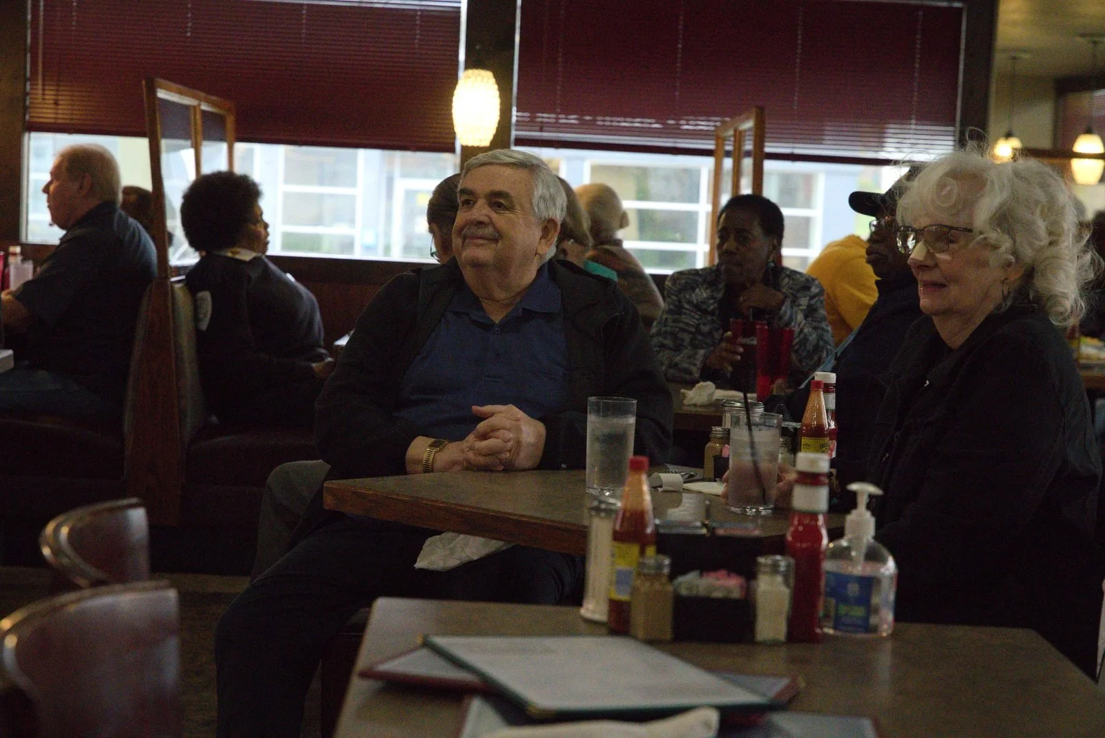 Guests sit together at a dining table listening to the live performance.