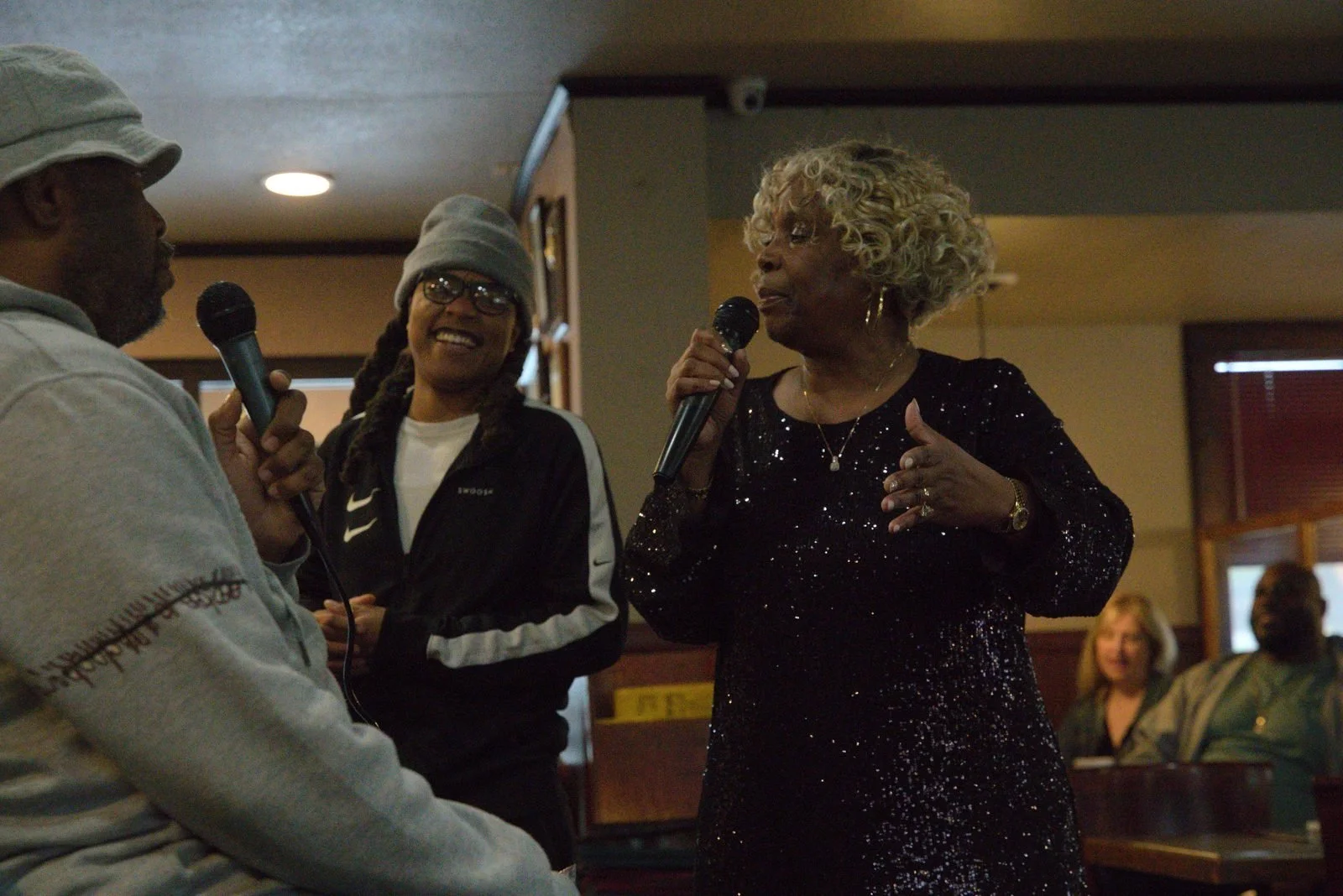Performers share a song with a smiling guest between them at Niecie’s.