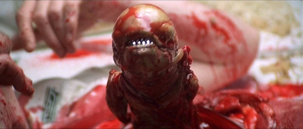Chest-burster xenomorph from Alien emerges.