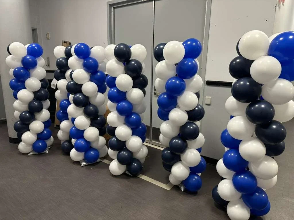 Behind the scenes balloon columns in blue navy and white ready for NYC school graduation installation