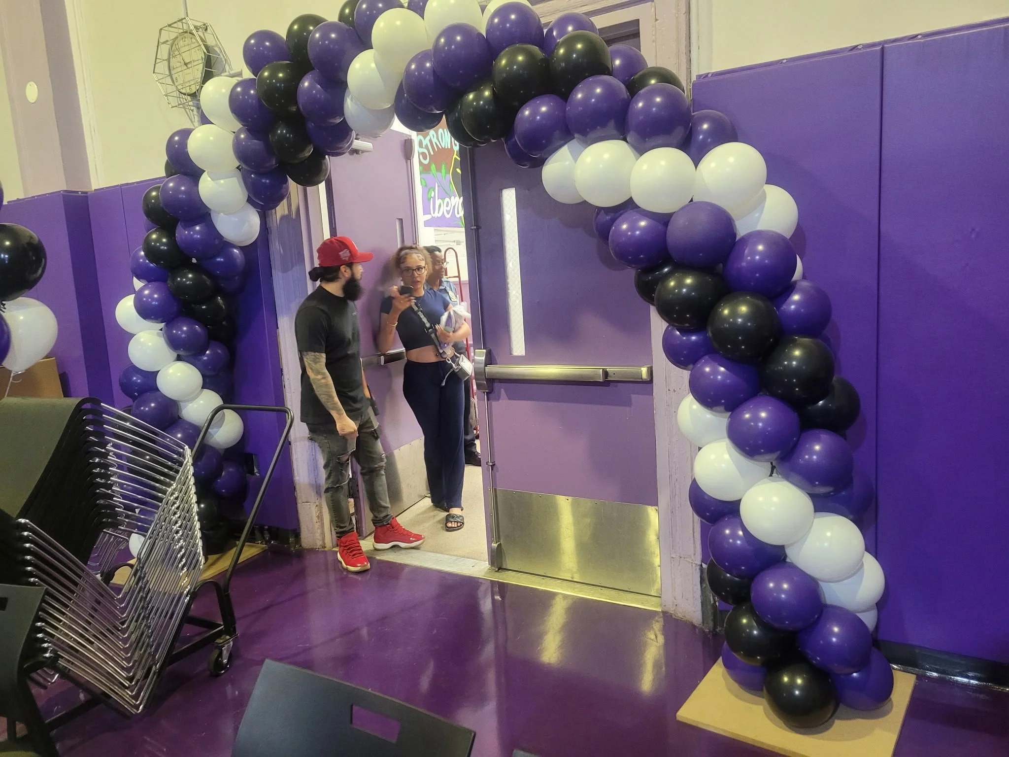 Purple black and white graduation balloon entrance arch at Liberation Diploma Plus High School Brooklyn NYC