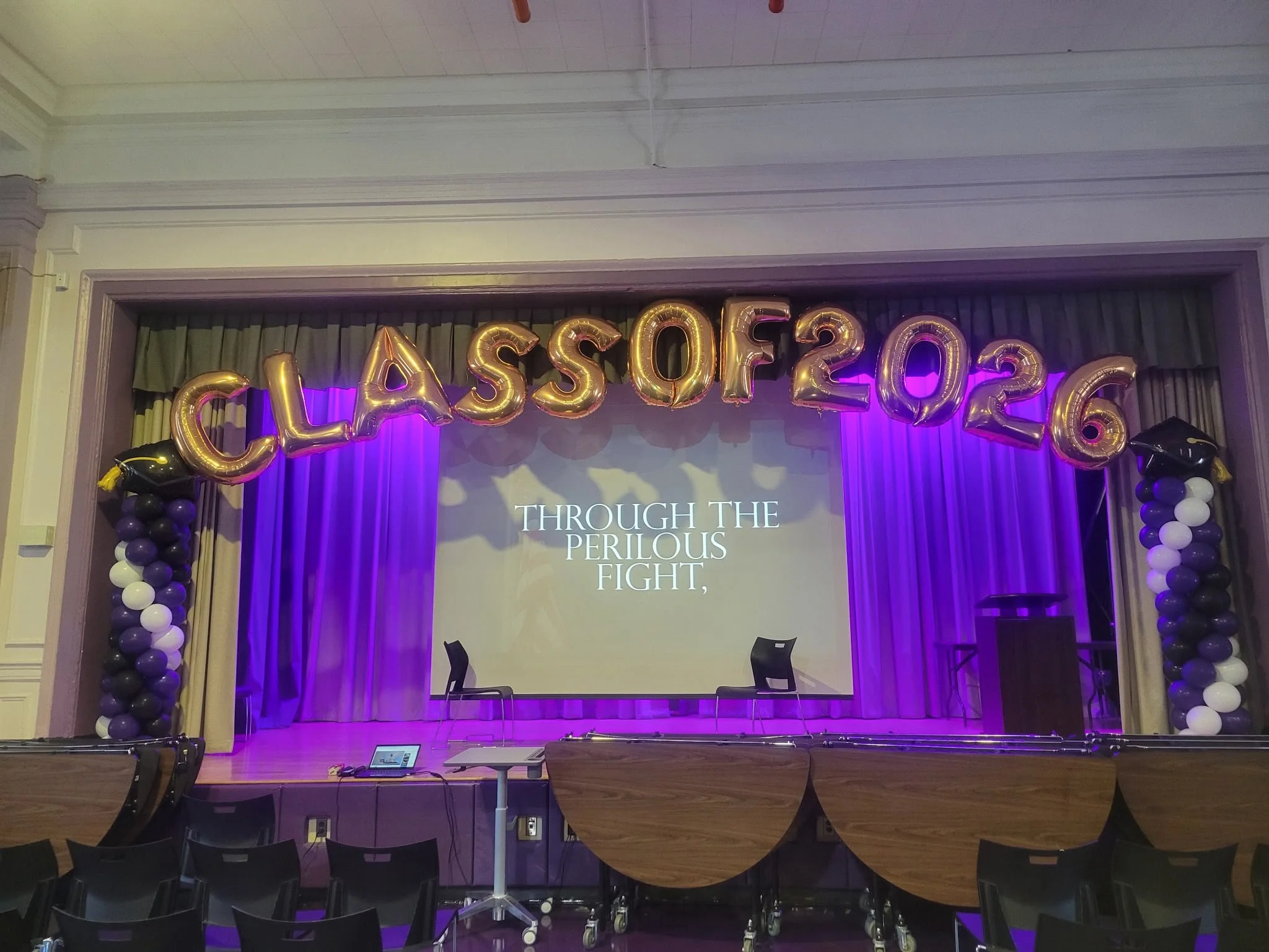 Class of 2026 gold foil letters and purple black white balloon columns at Liberation Diploma Plus High School graduation Brooklyn NYC