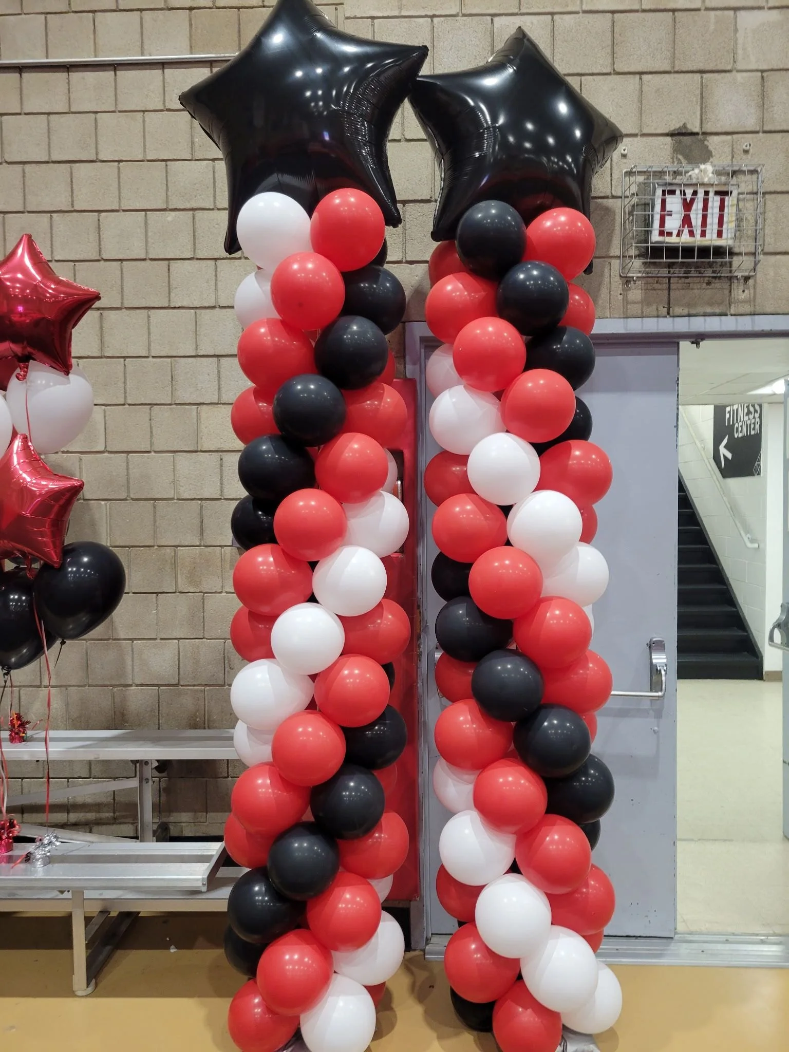 Spiral balloon columns with black star foil toppers in black red white for LaGuardia College Queens NYC