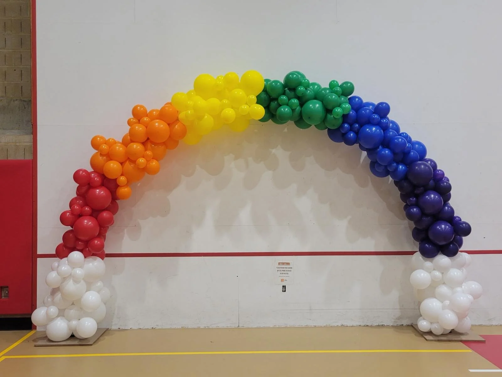 25-foot organic rainbow balloon arch for Queens Lavender Graduation at LaGuardia Community College NYC