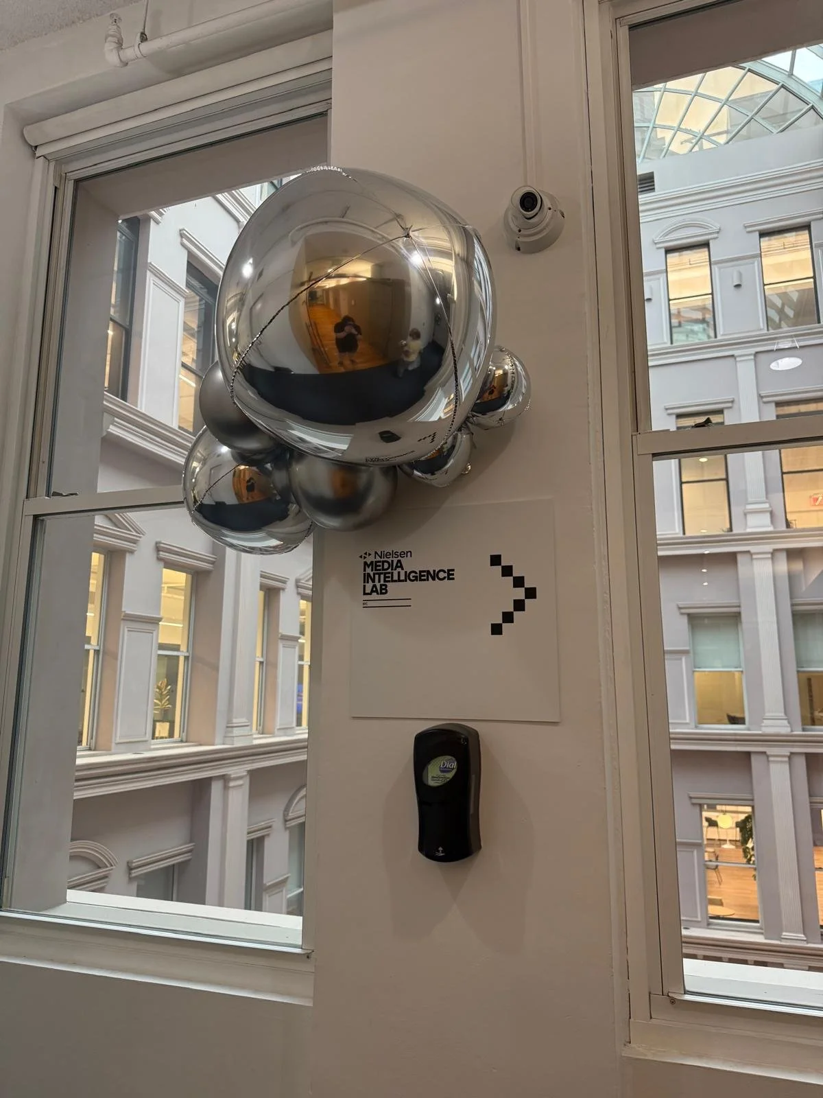 Silver balloon cluster and Media Intelligence Lab sign by a window at Nielsen in Chelsea NYC
