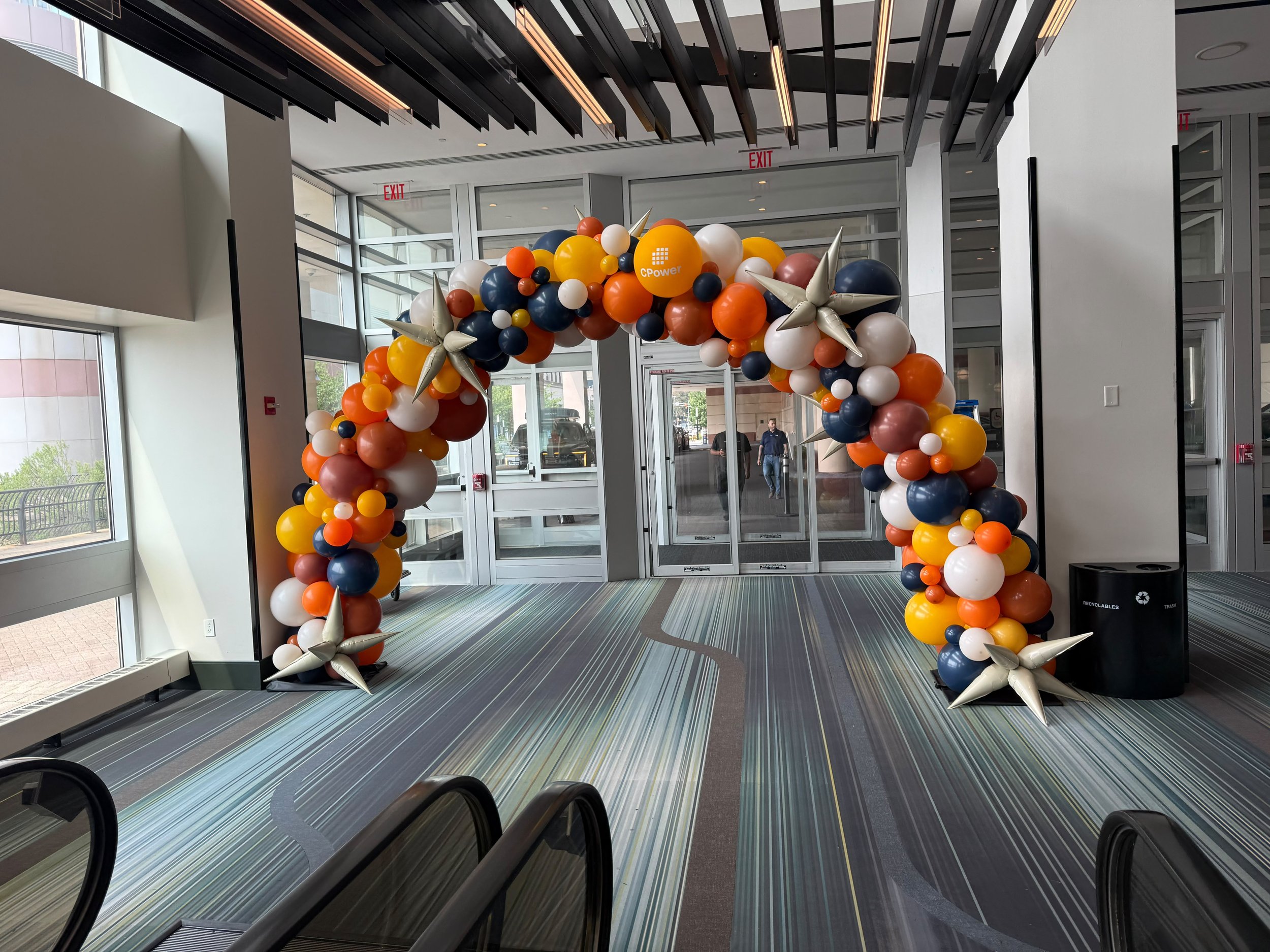 Organic balloon arch entrance with starburst accents for a CPower corporate event Jersey City NJ