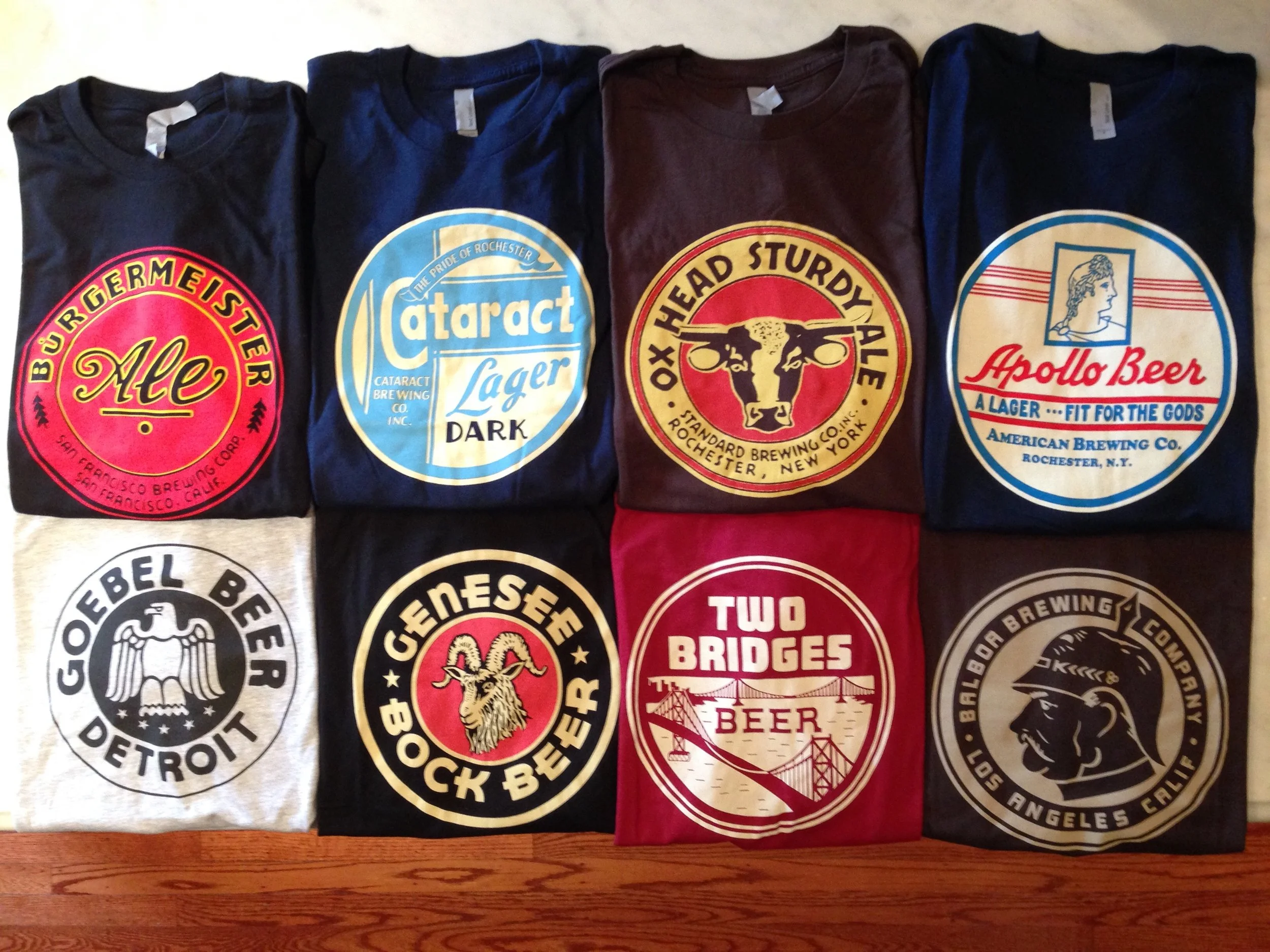 A flat-lay grid of the recreated vintage brewery tees