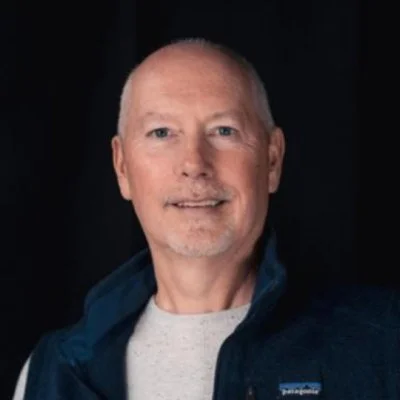 Jim Grunder smiling wearing a grey shirt. 