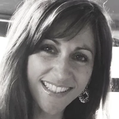 Angela Anastasakis smiling in a black and white photo. 