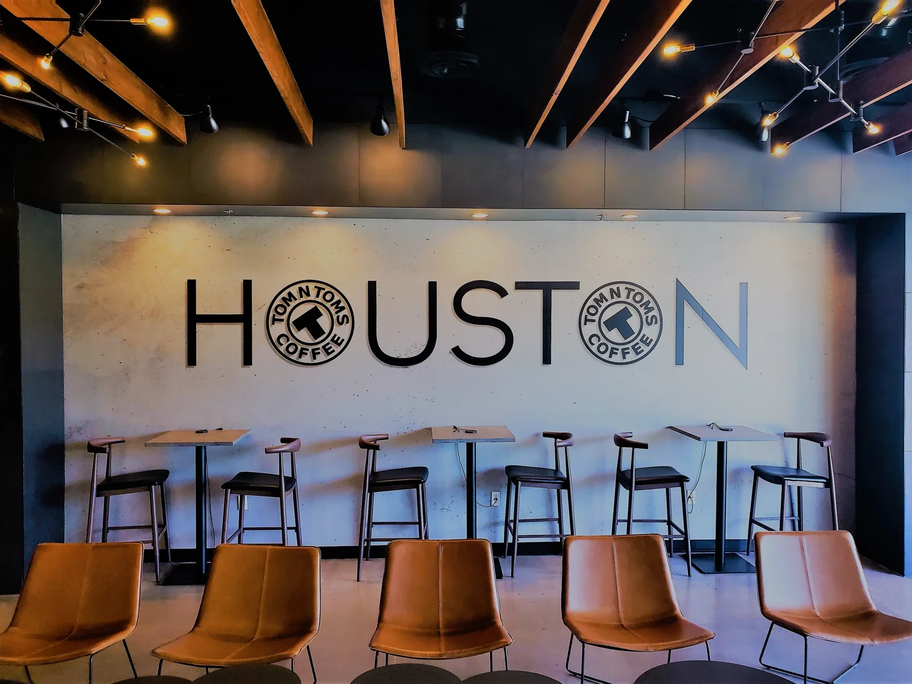 Seating beneath the Houston mural inside TOM N TOMS Bellaire