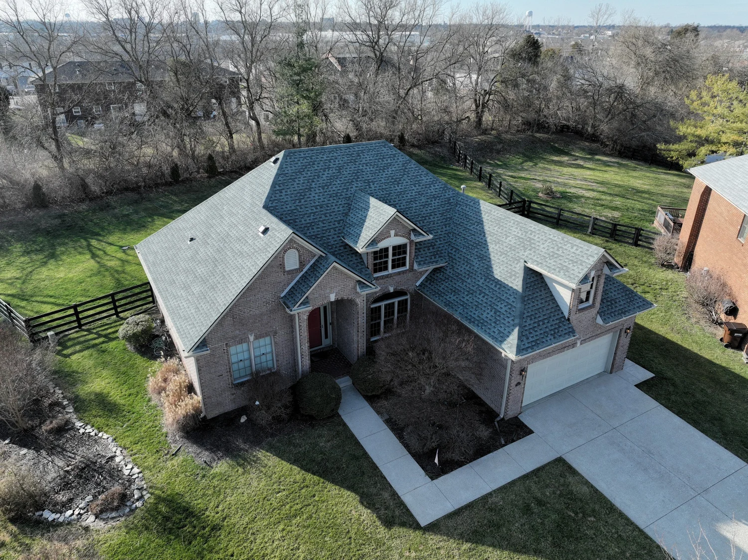 Front aerial view of a completed Reformation asphalt-shingle roof on a two-story brick home