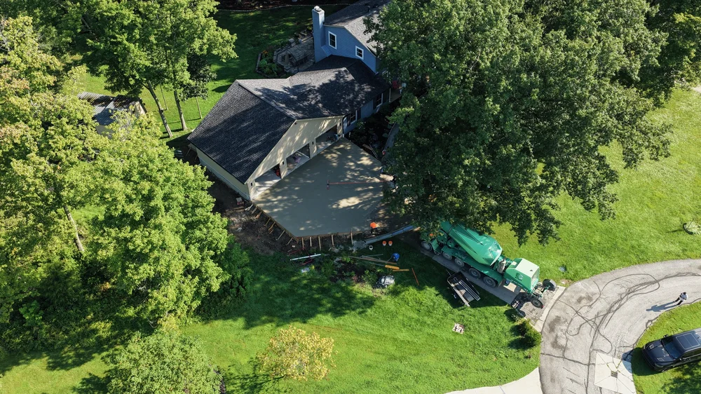 Aerial view of a garage addition connected to the existing house during concrete work