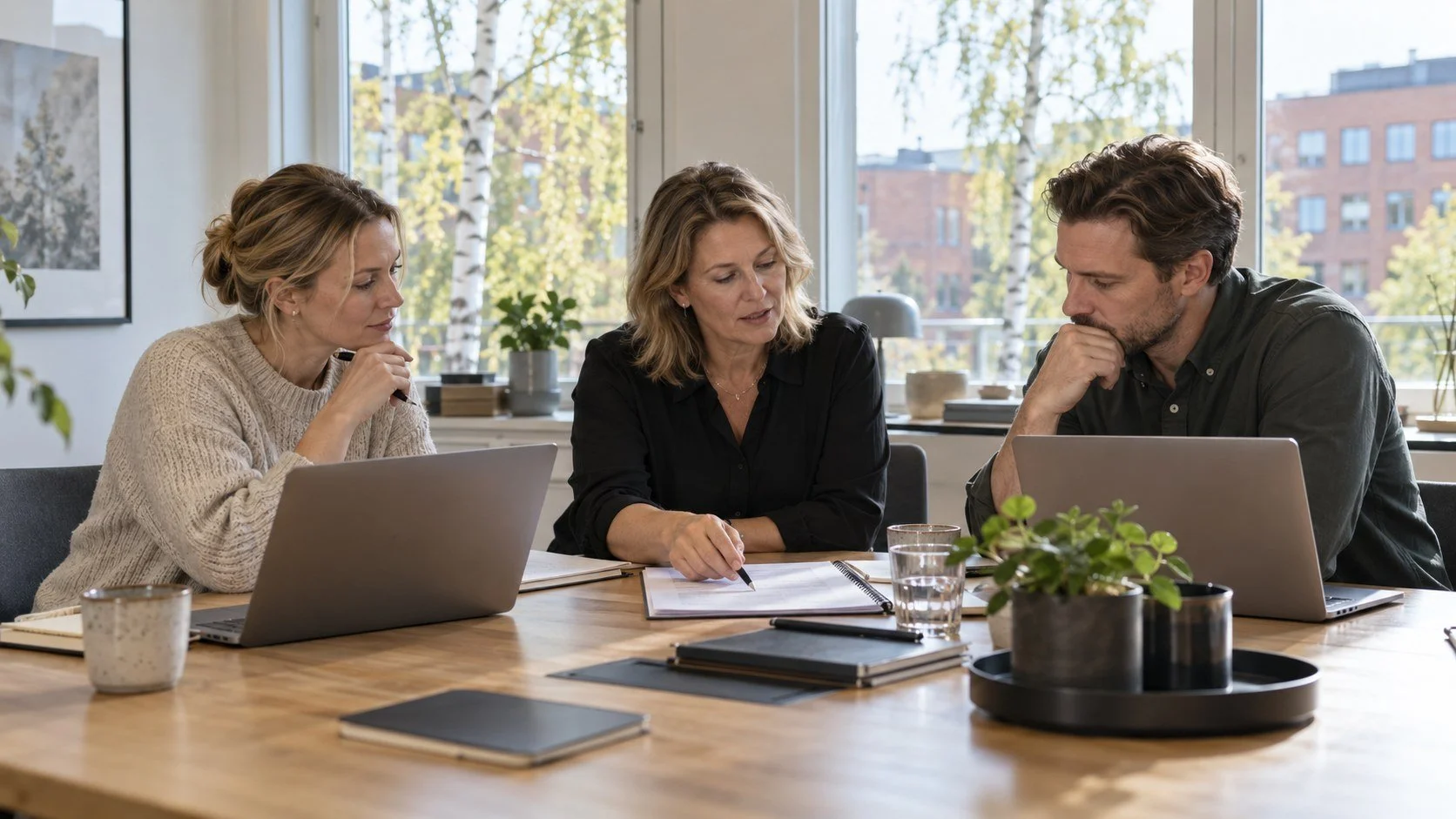 Kollegor planerar ett systembyte i ett ljust svenskt kontor