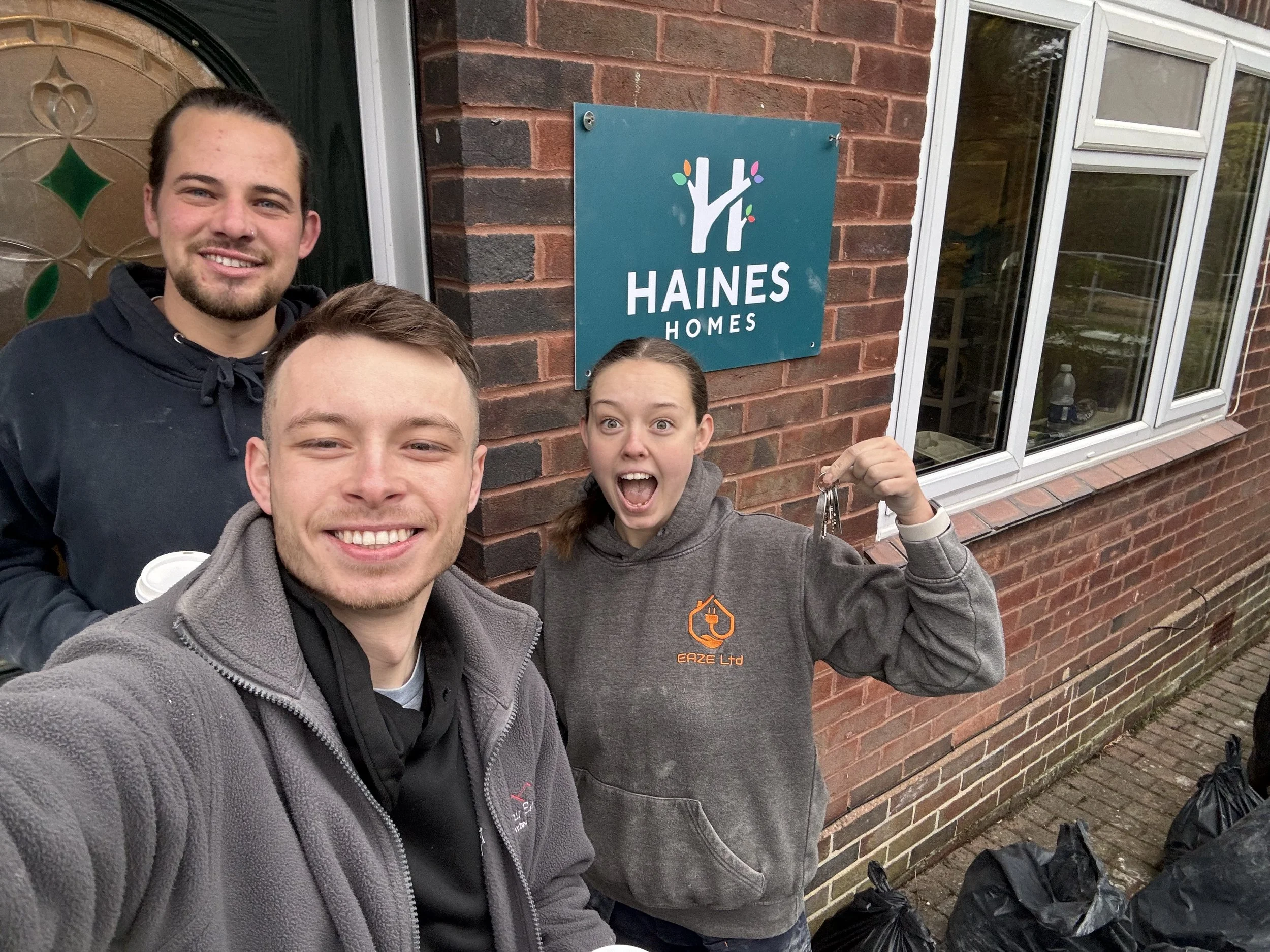 Josh, Katie, and Jacob picking up the keys to a Lease Option property flip.
