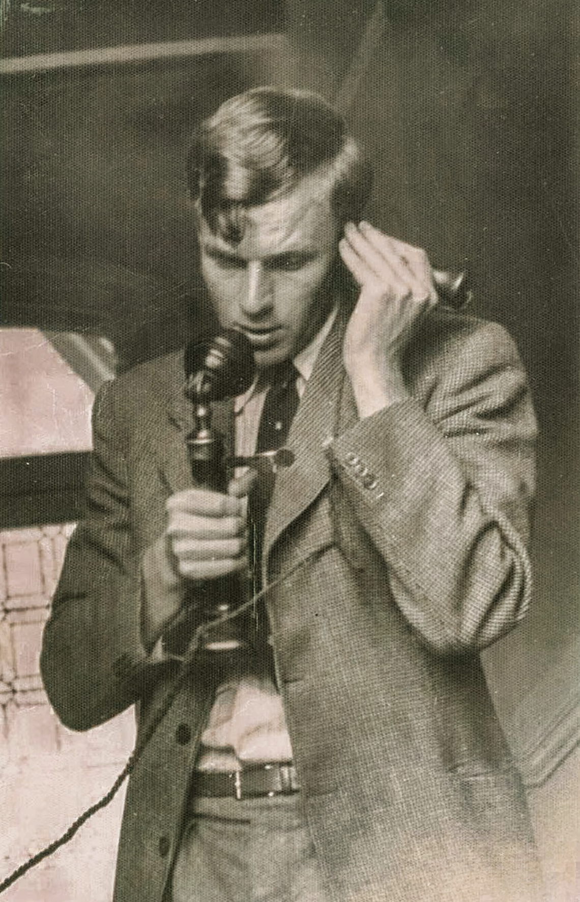 John Gerrard in his early twenties using a telephone