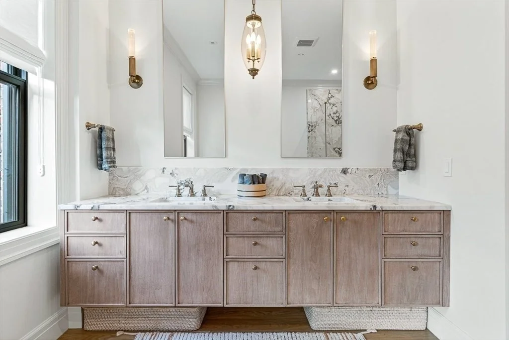 Artisans bathroom with double vanity and brass lighting