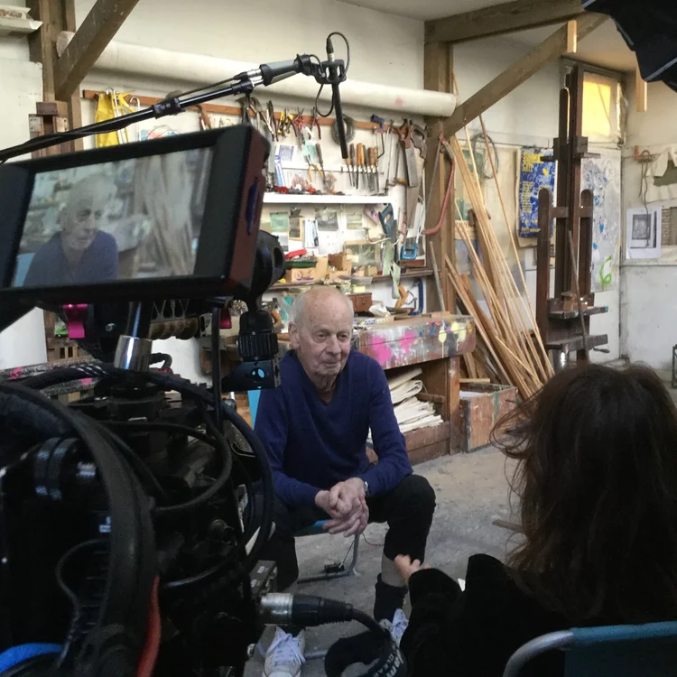 Lita Albuquerque in her Los Angeles studio. The artist is wearing all black and ultramarine blue shoes.