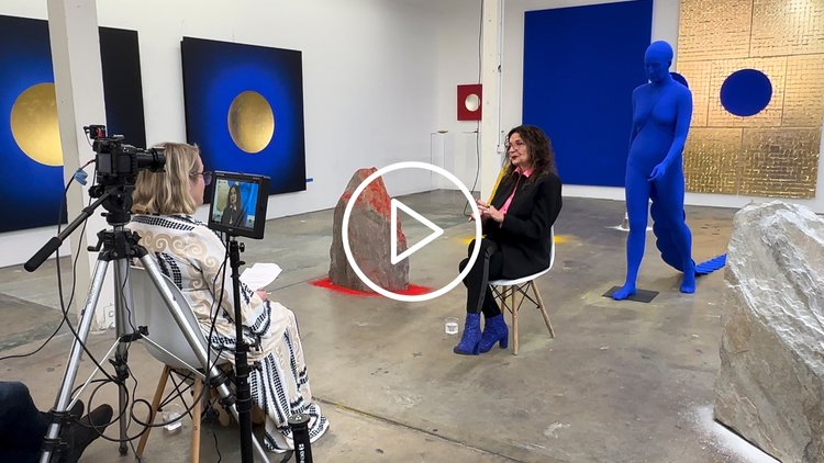 Lita Albuquerque in her Los Angeles studio. The artist is wearing all black and ultramarine blue shoes.