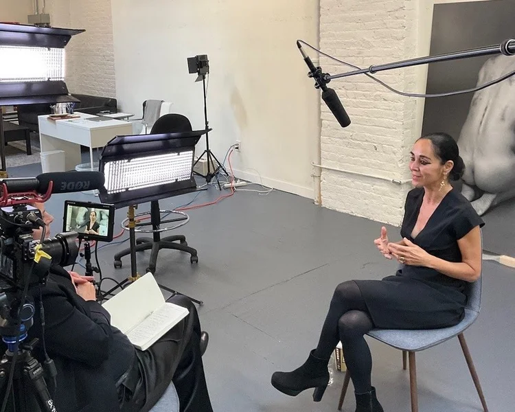 Lita Albuquerque in her Los Angeles studio. The artist is wearing all black and ultramarine blue shoes.