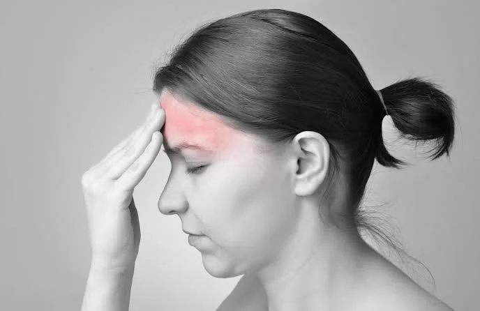 Woman pressing her fingers to her forehead with a headache