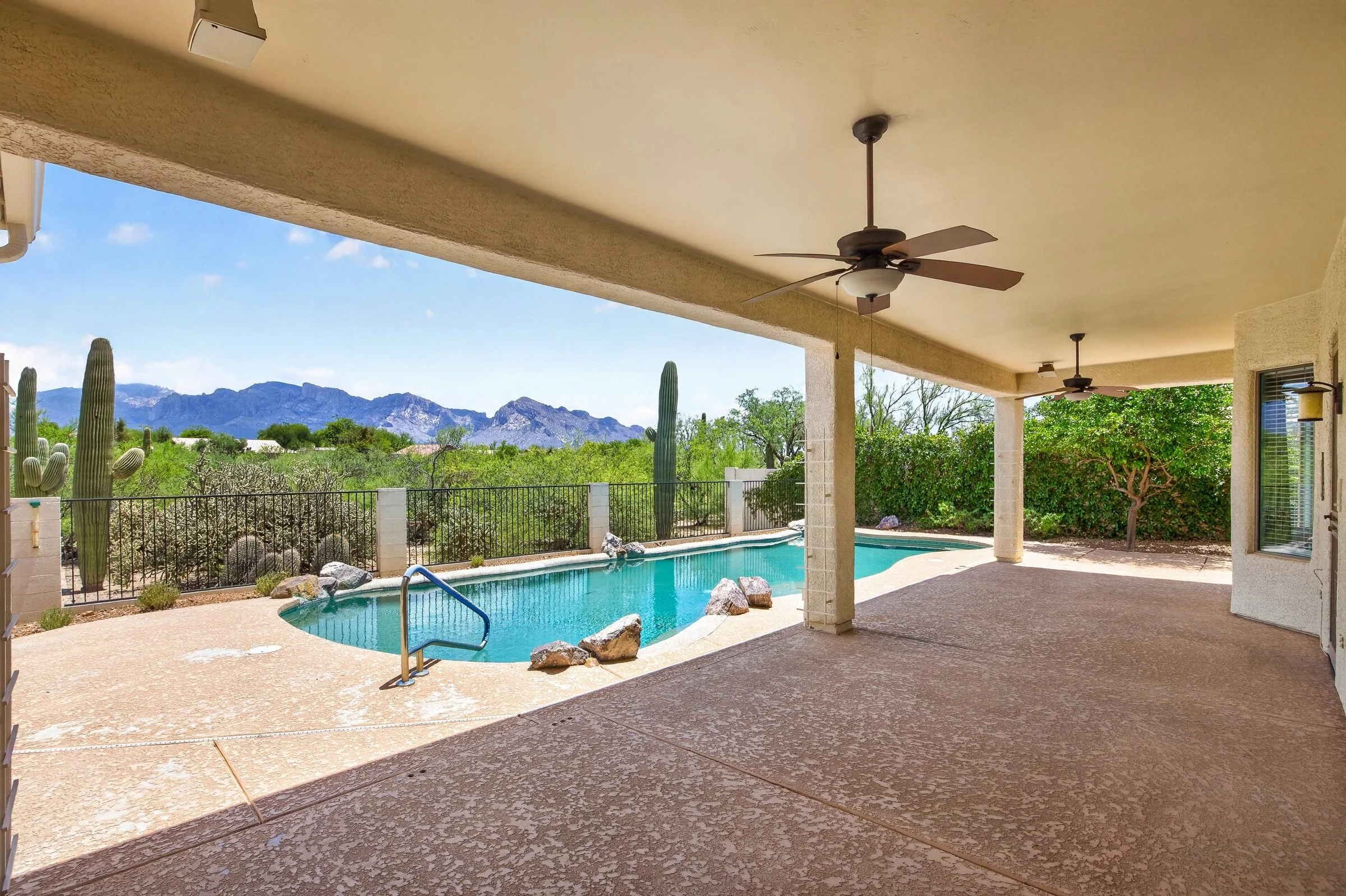 Covered rear patio with ceiling fans overlooking the pool and the Santa Catalina Mountains