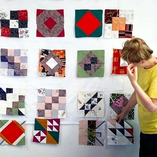 Frau vor Wand mit vielen Patchworks