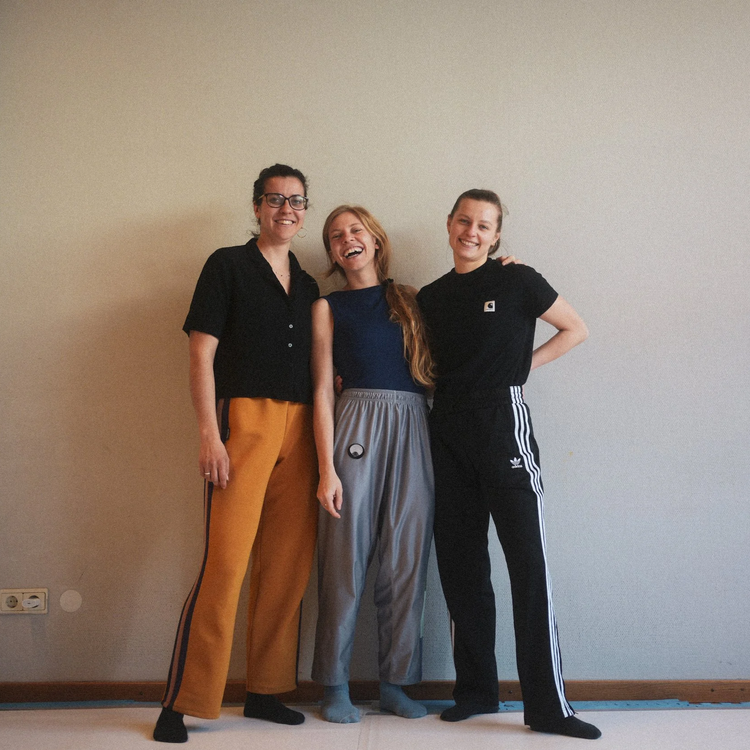 Drei lachende Frauen im Stehen. 