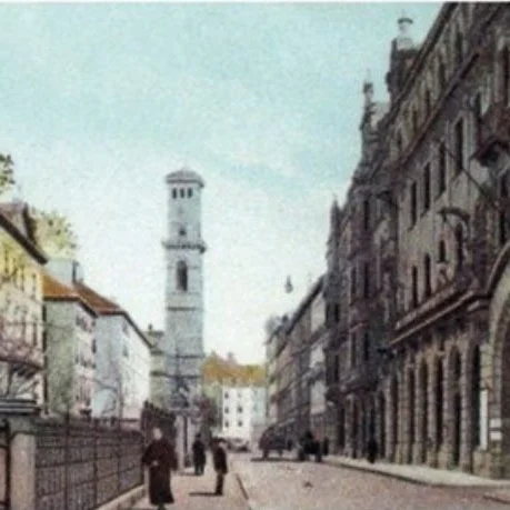 Altes Bild eines Straßenzugs, im Hintergrund ein Kirchturm.