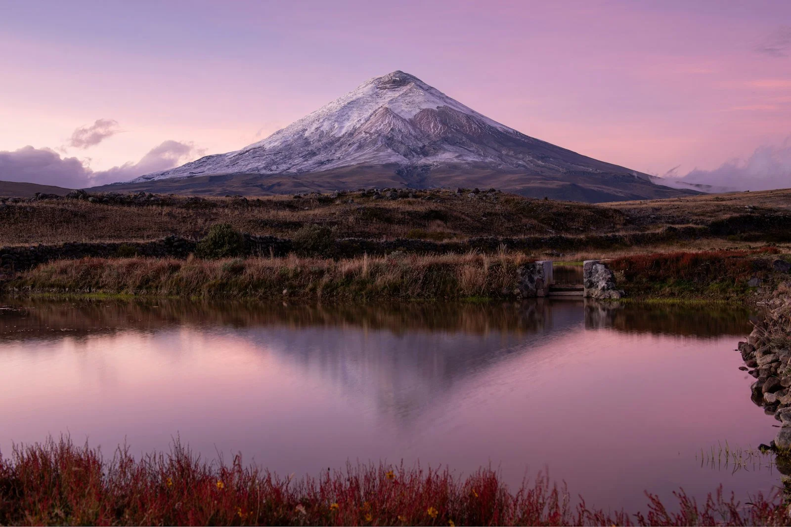 A volcano reflected in a lake at sunset
