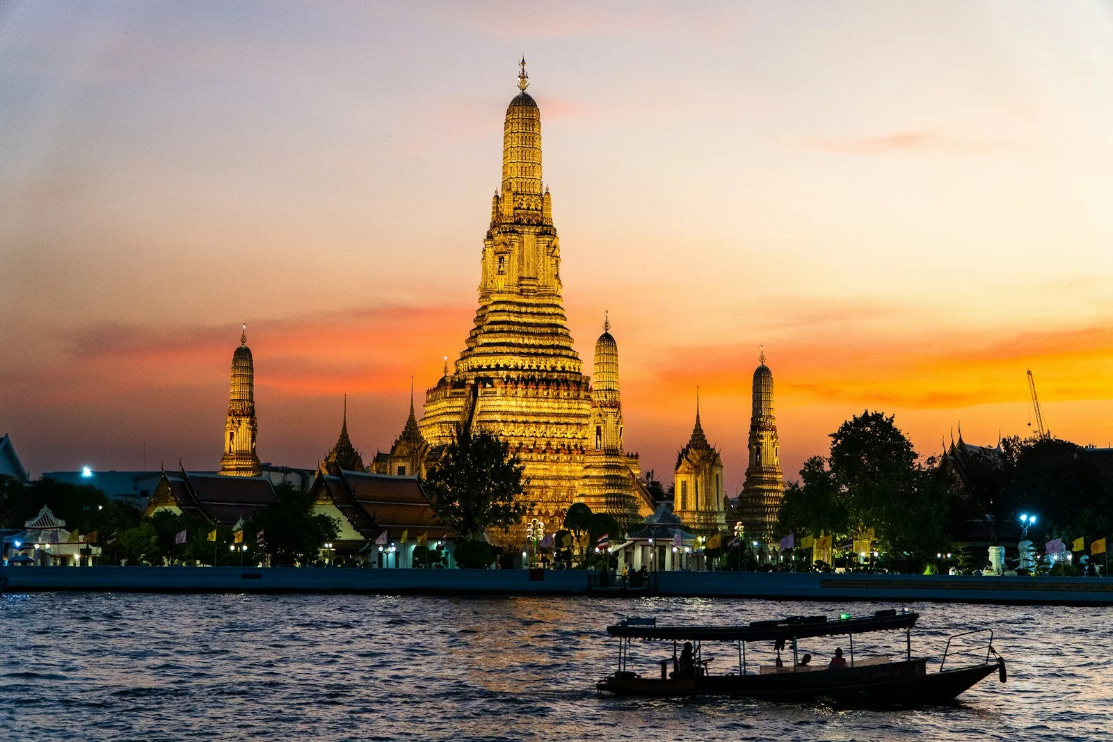 Wat Arun glowing at sunset on the Chao Phraya River, Bangkok