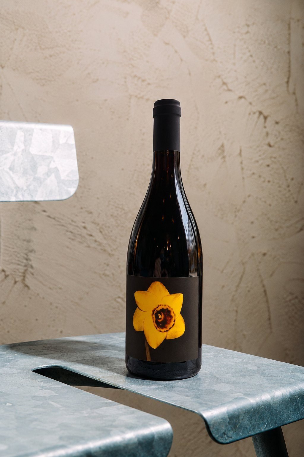 Bottle of Narcisa, Win's own red wine, on a zinc chair