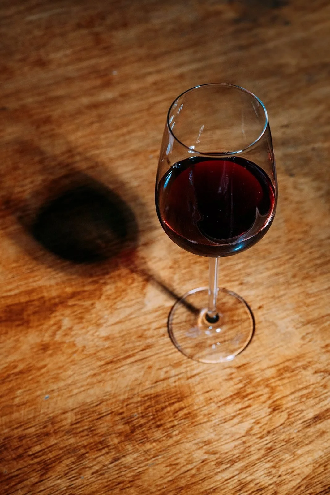 Glass of red natural wine on a wooden table