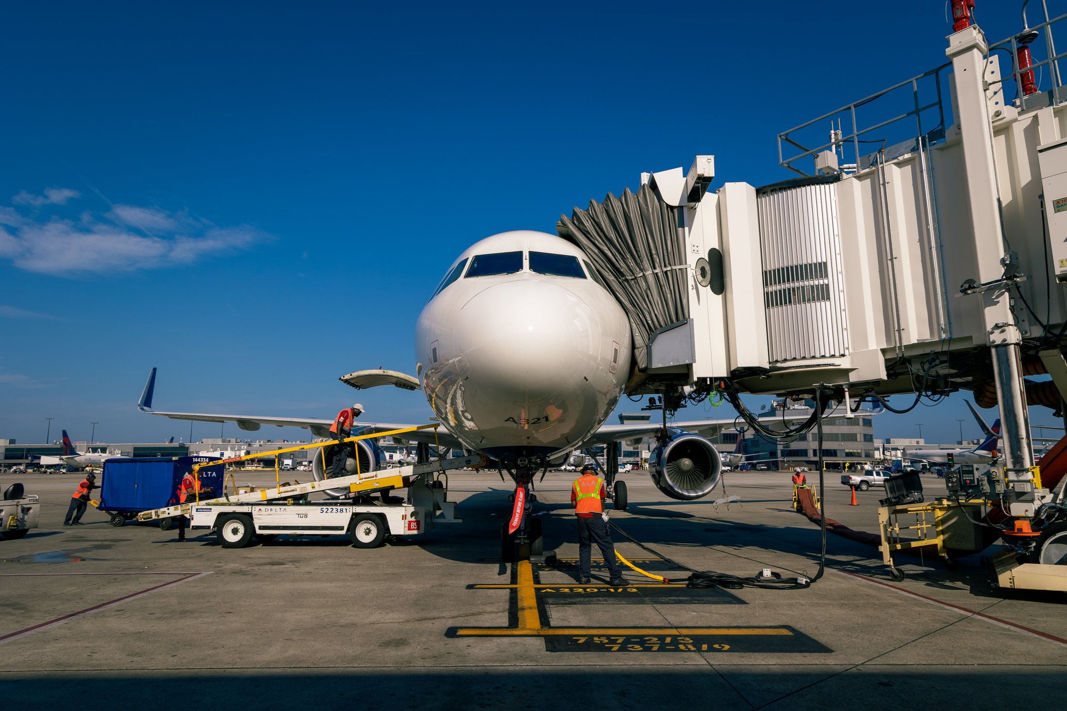 Aircraft at gate with passenger boarding bridge and airport ground operations