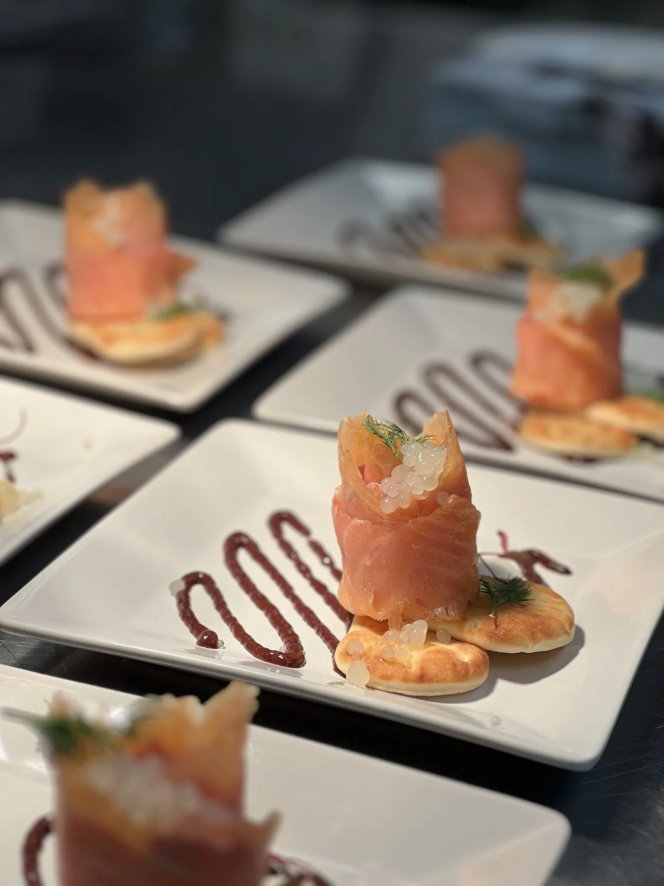 A carefully arranged appetizer with delicate garnishes and sauce on a white plate